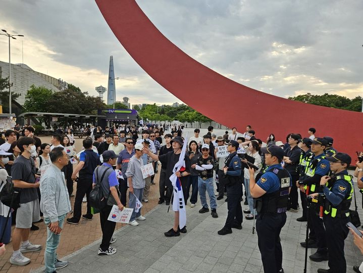[서울=뉴시스] 이태성 기자 = 9일 오후 서웊 송파구 방이동 올림픽공원 핸드볼경기장 앞 모습. 일부 시위 참가자가 체육 단체 관계자들에게 물리력을 행사하려 하자 태극기를 든 다른 참가자가 중재하고 있다. 2026.06.09. victory@newsis.com *재판매 및 DB 금지