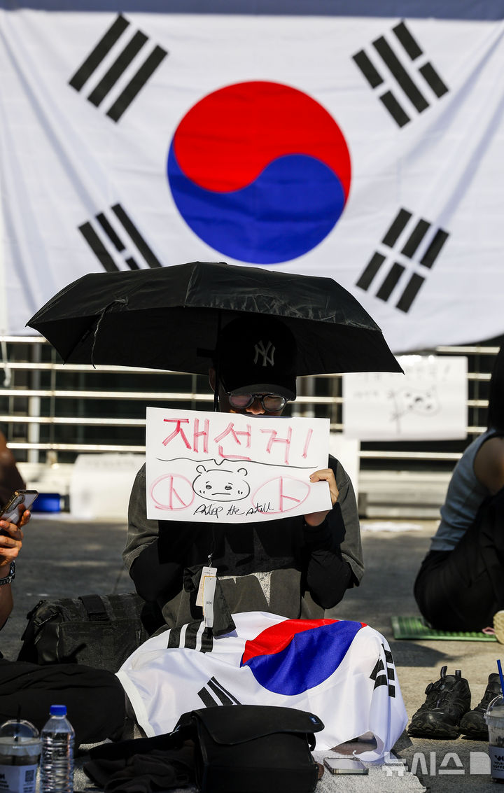 [서울=뉴시스] 정병혁 기자 = 제9회 전국동시지방선거 투표용지 부족 사태에 항의하며 개표소 봉쇄 시위를 이어가는 시민들이 9일 서울 송파구 올림픽공원 핸드볼경기장에 설치된 개표소 앞에 앉아 있다. 2026.06.09. jhope@newsis.com