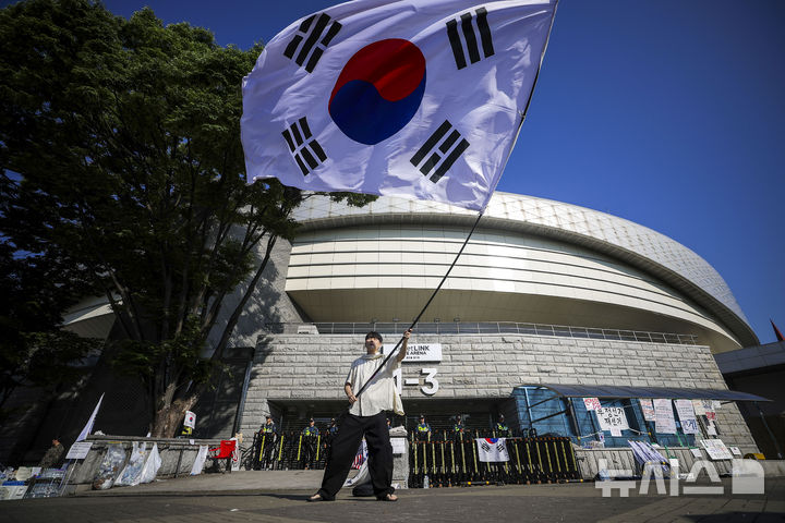 [서울=뉴시스] 정병혁 기자 = 제9회 전국동시지방선거 투표용지 부족 사태에 항의하며 개표소 봉쇄 시위를 이어가는 시민들이 9일 서울 송파구 올림픽공원 핸드볼경기장에 설치된 개표소 앞에서 재선거를 촉구하며 태극기를 흔들고 있다. 2026.06.09. jhope@newsis.com