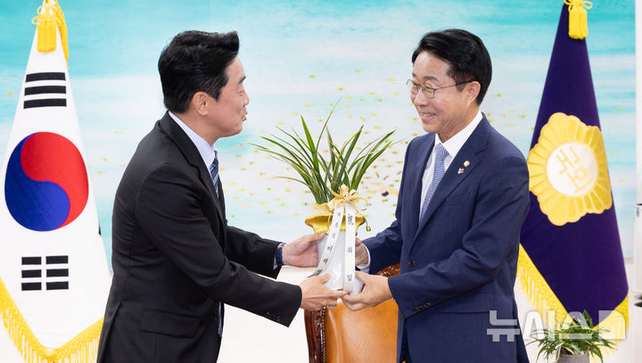 [서울=뉴시스] 김근수 기자 = 조정식(오른쪽) 국회의장이 9일 오전 서울 여의도 국회에서 강훈식 비서실장으로부터 이재명 대통령의 축하 난을 전달받고 있다. (공동취재) 2026.06.09. photo@newsis.com