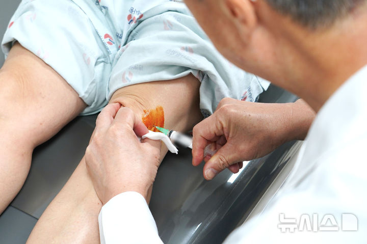 [서울=뉴시스] 고용곤 연세사랑병원 병원장이 무릎 관절염 환자에게 SVF 치료를 시행하고 있다. (사진= 연세사랑병원 제공)