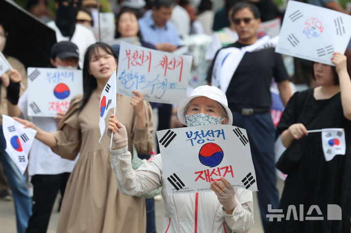 [서울=뉴시스] 권창회 기자 = 제9회 전국동시지방선거 투표용지 부족 사태에 항의하며 개표소 봉쇄 시위를 이어간 지난 10일 서울 송파구 올림픽공원 핸드볼경기장에 설치된 개표소 앞에서 시민들이 구호를 외치고 있다. 2026.06.10. kch0523@newsis.com