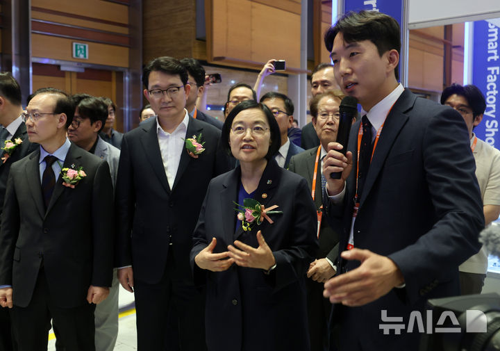 [서울=뉴시스] 이영환 기자 = 국무총리 후보자인 한성숙 중소벤처기업부 장관이 10일 오후 서울 강남구 코엑스에서 열린 'K-푸드 스마트제조 얼라이언스 출범식' 참석에 앞서 식품제조관 부스를 방문해 조경찬 학화1934 대표이사에게 호두과자 생산 자동화 공정에 대해 설명을 듣고 있다. 2026.06.10. 20hwan@newsis.com