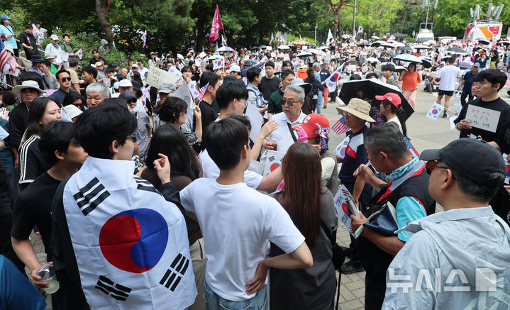 [서울=뉴시스] 권창회 기자 = 제9회 전국동시지방선거 투표용지 부족 사태에 항의하며 개표소 봉쇄 시위를 이어가고 있는 10일 서울 송파구 올림픽공원 핸드볼경기장에 설치된 개표소 앞에서 시민과 경찰이 대치상황이 벌어질뻔 하자 청년들이 이를 제지하고 있다. 2026.06.10. kch0523@newsis.com