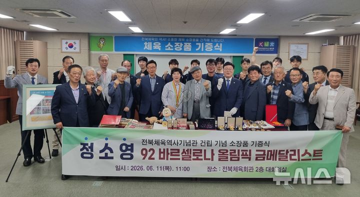 [전주=뉴시스] 1992 바르셀로나 올림픽 배드민턴 여자 복식 금메달리스트인 정소영 영웅이 11일 전북도체육회에서 체육 소장품 전달식을 가진 가운데 정강선 회장 등 관계자들과 기념촬영을 하고 있다. 2026.06.11 *재판매 및 DB 금지