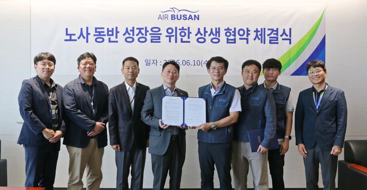 [부산=뉴시스] 정병섭 에어부산 대표이사(왼쪽에서 네 번째)와 남이훈 에어부산 조종사노동조합 위원장(다섯 번째)을 비롯한 노사 관계자들이 지난 10일 자사 사옥에서 상생 협약을 체결한 후 기념촬영을 하고 있다. (사진=에어부산 제공) 2026.06.11. photo@newsis.com *재판매 및 DB 금지
