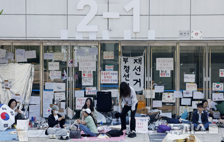 [서울=뉴시스] 김혜진 기자 = 제9회 전국동시지방선거 투표용지 부족 사태에 항의하며 개표소 봉쇄 시위를 이어가고 있는 11일 서울 송파구 올림픽공원 핸드볼경기장 인근 매표소에 재선거를 촉구하는 피켓들이 붙어 있다. 2026.06.11. jini@newsis.com