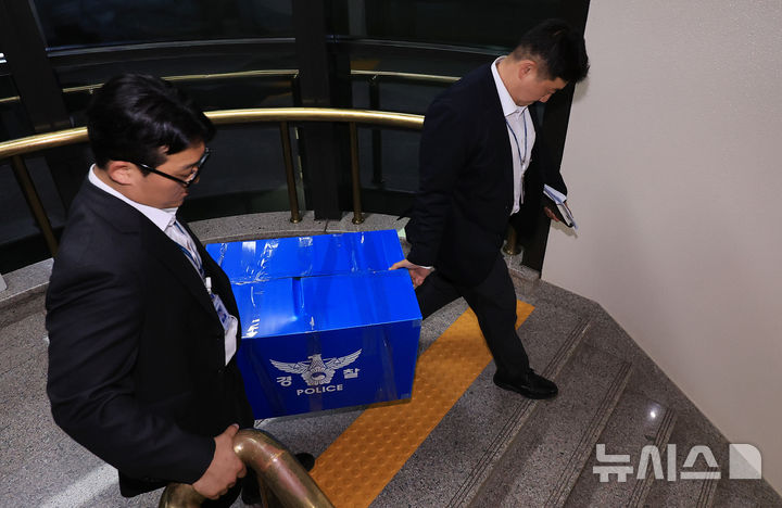 [과천=뉴시스] 박주성 기자 = 6·3 지방선거 투표지 부족사태 사건을 수사 중인 서울경찰청 광역범죄수사대 수사관들이 11일 경기도 과천시 중앙선거관리위원회에서 압수수색을 마친 뒤 압수품을 들고 이동하고 있다. (공동취재) 2026.06.11. photo@newsis.com