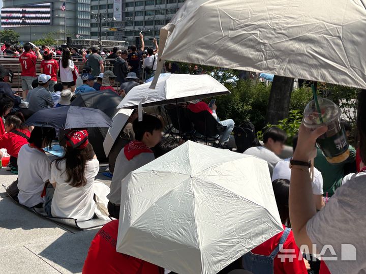 [서울=뉴시스] 권민지 기자 = 거리응원에 나선 시민들이 내리쬐는 햇빛을 막기 위해 우산, 양산을 쓰고 있다. 2026.06.12. ming@newsis.com