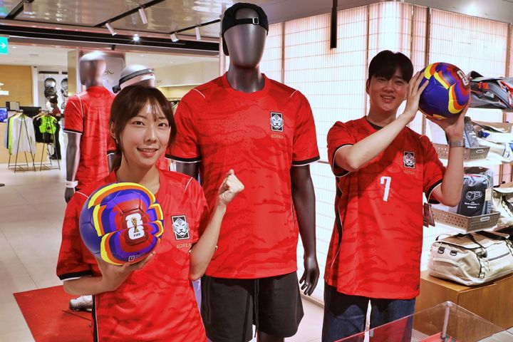 [서울=뉴시스] 롯데백화점 본점 7층 스포츠 매장에서 모델들이 2026 FIFA 북중미 월드컵 공식 굿즈를 홍보하고 있다. (사진=롯데백화점 제공) 2026.06.13. photo@newsis.com *재판매 및 DB 금지