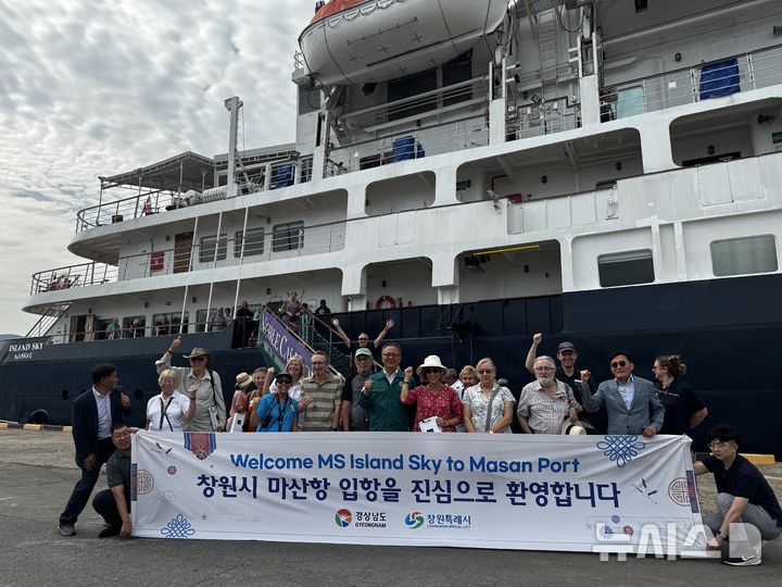 [창원=뉴시스]14일 경남 창원시 마산합포구 마산항 3부두에 입항한 영국 노블 칼레도니아사 4200t급 럭셔리 크루즈선 'Ms Island Sky'호 승객들이 경남도와 창원시의 환영 속에 기념촬영하고 있다.(사진=경남도 제공) 2026.06.14. photo@newsis.com