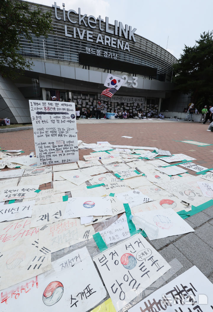 [서울=뉴시스] 박주성 기자 = 제9회 전국동시지방선거 투표용지 부족 사태에 항의하며 개표소 봉쇄 시위를 이어가고 있는 14일 서울 송파구 올림픽공원 핸드볼경기장에 설치된 개표소 앞에 시민들이 써 놓은 문구들이 붙어 있다. 2026.06.14. park7691@newsis.com