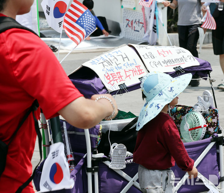 [서울=뉴시스] 박주성 기자 = 제9회 전국동시지방선거 투표용지 부족 사태에 항의하며 개표소 봉쇄 시위를 이어가고 있는 14일 서울 송파구 올림픽공원 핸드볼경기장에 설치된 개표소 앞에 한 시민들이 재선거 문구를 붙이고 이동하고 있다. 2026.06.14. park7691@newsis.com