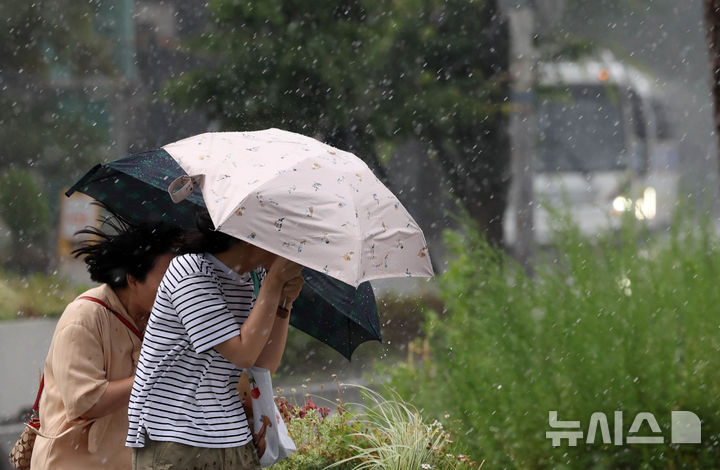 [서울=뉴시스] 조수정 기자 = 서울 전역에 소나기가 내린 14일 서울 종로구 광화문광장에서 시민들이 우산을 들고 걸어가고 있다. 2026.06.14. chocrystal@newsis.com