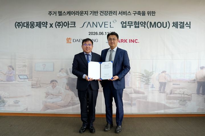 [서울=뉴시스] 박형철 대웅제약 ETC마케팅본부장(왼쪽)과 김병기 아크 인프라사업본부장이 주거단지 기반 프리미엄 AI 헬스케어 라운지 '상벨'(SANVEL) 건강관리 서비스 사업 협력을 위한 업무협약을 체결하고 기념 촬영을 하고 있다. (사진=대웅제약 제공) 2026.06.15. photo@newsis.com *재판매 및 DB 금지