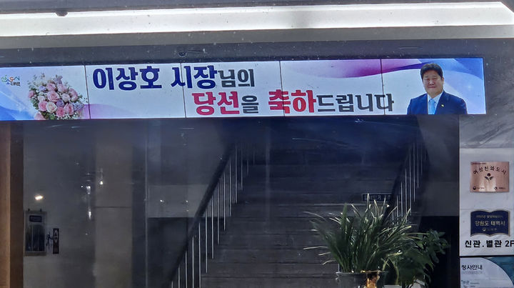 지난 2일 저녁 태백시청 청사 1층 로비 전광판에는 개표 결과가 나오기 전임에도 불구하고 ‘이상호 시장님의 당선을 축하드립니다’라는 문구와 함께 국민의힘 이상호 후보의 사진과 꽃다발 이미지가 송출된 모습.(사진=독자 제공) *재판매 및 DB 금지