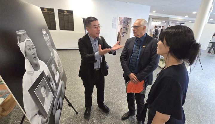 [서울=뉴시스] 양종훈(왼쪽) 상명대 석좌교수 겸 제주해녀문화협회 이사장이 11일 스위스 제네바 IUCN 전시홀에서 관람객에게 사진 작품을 설명하고 있다. (사진=상명대 제공) 2026.06.15. photo@newsis.com *재판매 및 DB 금지