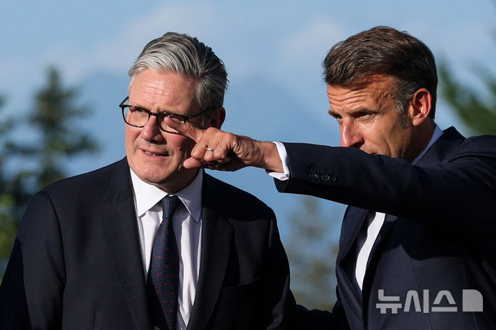 French President Emmanuel Macron speaks with Britain's Prime Minister Keir Starmer during the official arrivals ceremony for the G7 summit in Evian-les-Bains, France, Monday, June 15, 2026. (Isabel Infantes, Pool Photo via AP)