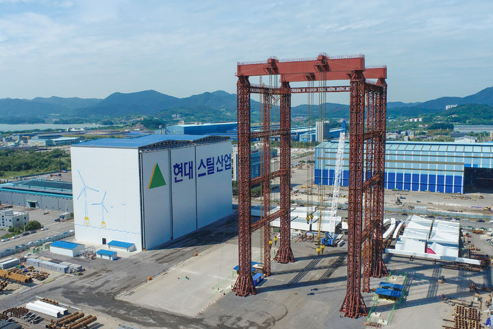[광양=뉴시스] 광양만권경제자유구역 율촌1산단 현대스틸산업 율촌공장에 완공된 해상풍력 전용 마감장(왼쪽)과 대형 인양장비(오른쪽) 전경.(사진=광양경자청 제공) 2026.06.16. photo@newsis.com *재판매 및 DB 금지