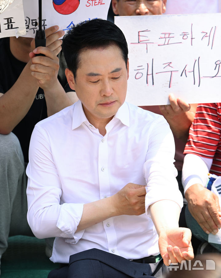 [서울=뉴시스] 고승민 기자 = 장동혁 국민의힘 대표가 16일 6·3 지방선거 투표용지 부족 사태를 규탄하는 개표소 봉쇄 시위가 이어지고 있는 서울 올림픽공원 핸드볼경기장 앞을 찾아 자리를 깔고 앉아 있다. (공동취재) 2026.06.16. photo@newsis.com