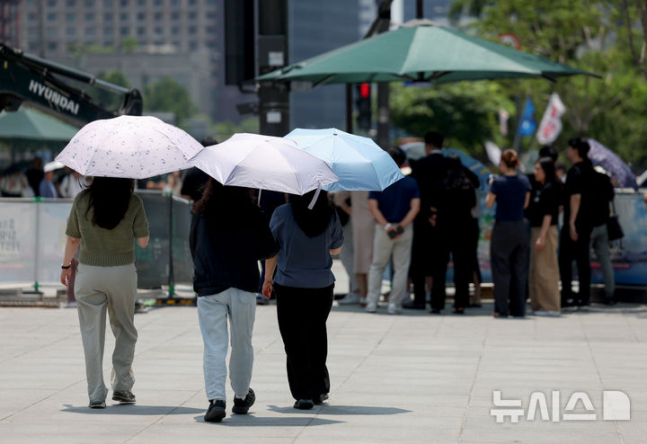 [서울=뉴시스] 김진아 기자 = 전국 대부분 지역에서 낮 기온이 30도 이상으로 오르며 무더운 날씨가 이어지고 있는 16일 서울 종로구 광화문광장에서 시민들이 햇빛을 피하기 위해 양산을 쓰고 있다. 2026.06.16. bluesoda@newsis.com