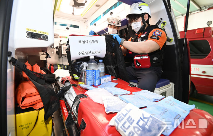 [수원=뉴시스] 김종택 기자 = 무더운 날씨를 보인 지난달 16일 경기 수원시 권선구 수원남부소방서 권선119안전센터 구급대원들이 온열 질환자 발생에 대비해 구급 차량 내 얼음조끼와 아이스팩 등 폭염대비 물품을 점검하고 있다. 2026.06.16. jtk@newsis.com