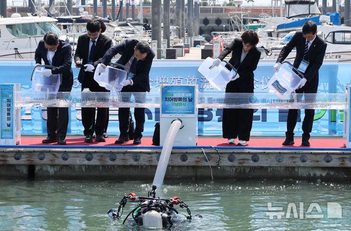 [인천=뉴시스] 전진환 기자 = 16일 오후 인천 왕산마리나항에서 열린 2026 한·중 공동 치어방류의 날 기념행사에서 양국 참석자들이 참조기 치어를 방류하고 있다. 2026.06.16. amin2@newsis.com
