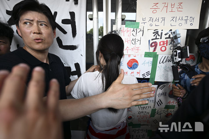 [서울=뉴시스] 이영환 기자 = 지난 16일 서울 올림픽공원 핸드볼경기장에서 한 시위 참가자가 대한체육회 등 입주 단체 관계자들의 진입을 막아서고 있다. (공동취재) 2026.06.16. photo@newsis.com