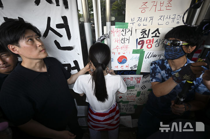 [서울=뉴시스] 이영환 기자 = 16일 서울 올림픽공원 핸드볼경기장에서 한 시위 참가자가 대한체육회 등 입주 단체 관계자들의 진입을 막아서고 있다. (공동취재) 2026.06.16. photo@newsis.com