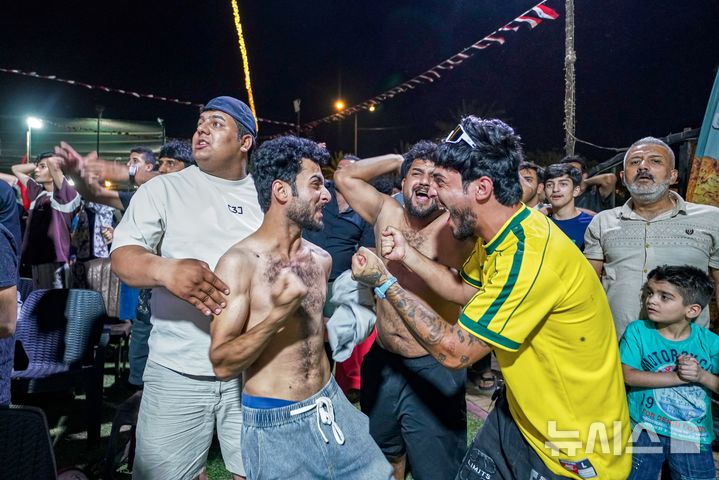 [바그다드=AP/뉴시스] 17일 새벽(현지 시간) 이라크 바그다드 시내에서 이라크 축구 팬들이 2026 국제축구연맹(FIFA) 북중미 월드컵 조별리그 I조 1차전 이라크(57위)와 노르웨이(31위)의 경기 전반 39분 터진 동점 골에 환호하고 있다. 이라크는 아이멘 후세인이 동점 골과 자책골을 기록하며 1-4로 패했다. 2026.06.17.