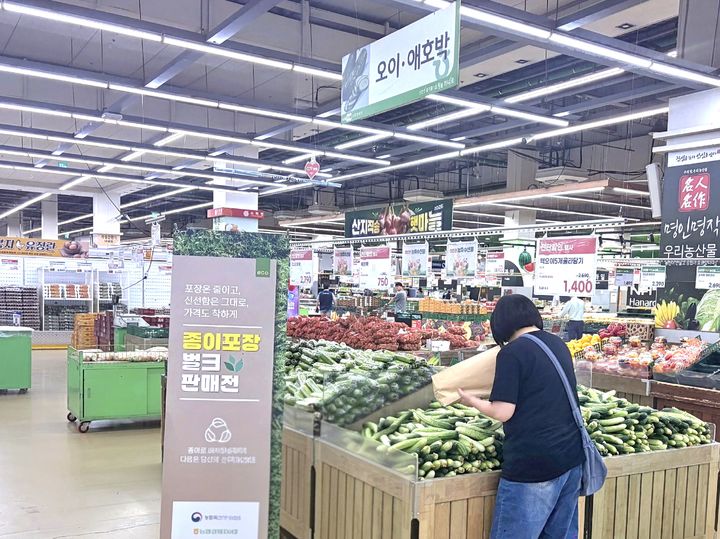 [세종=뉴시스] 서울 서초구 농협하나로마트 양재점을 방문한 고객이 종이봉투에 오이를 담고 있다. (사진=농협하나로마트 제공) *재판매 및 DB 금지