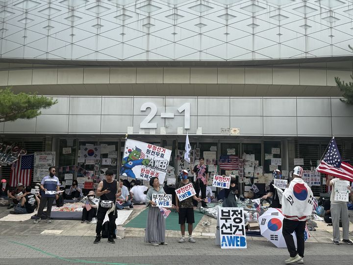 [서울=뉴시스] 6·3 지방선거 '투표용지 부족 사태'를 규탄하는 잠실 개표소 봉쇄 시위가 13일째 이어지고 있다. 사진은 17일 오전 2-1 게이트 앞에 모인 시위대 모습.뉴시스DB.2026.06.17.photo@newsis.com *재판매 및 DB 금지 *재판매 및 DB 금지
