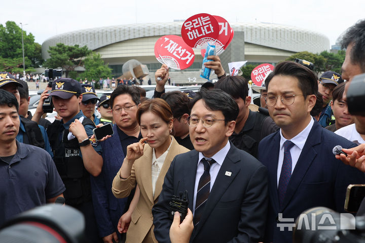 [서울=뉴시스] 권창회 기자 = 천준호, 임오경, 전용기 더불어민주당 의원들이 17일 6·3 지방선거 투표용지 부족 사태에 반발한 시민들이 시위를 이어가고 있는 서울 올림픽공원 핸드볼경기장을 찾아 발언을 하고 있다. 2026.06.17. kch0523@newsis.com