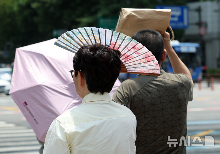 [서울=뉴시스] 이영환 기자 = 서울의 낮기온이 30도를 넘어서며 더위가 이어지고 있는 17일 서울 종로구 광화문광장에서 시민이 부채로 햇빛을 가리고 있다. 2026.06.17. 20hwan@newsis.com
