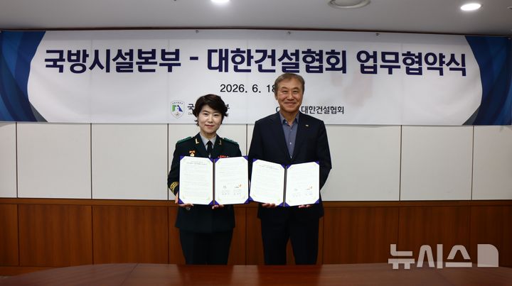 [서울=뉴시스] 강영미 국방시설본부장과 한승구 대한건설협회장이 업무협약서를 들고 기념촬영을 하고 있다.