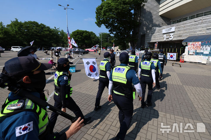 [서울=뉴시스] 조성우 기자 = 지난 18일 오전 6·3 지방선거 투표용지 부족 사태를 규탄하는 시위가 14일째 열리고 있는 서울 송파구 올림픽공원 핸드볼경기장 앞에서 경찰이 이동하고 있다. 2026.06.27. xconfind@newsis.com