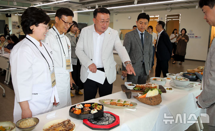 [제주=뉴시스] 우장호 기자 = 강동훈(가운데) 제주특별자치도관광협회 회장이 18일 오전 제주시 일도1동 제주소통협력센터 5층에서 열린 '2026 제주 식도락 관광객 유치 조성 사업 제주미(味)행' 시작에 앞서 명인들과 향토음식을 둘러보고 있다. 2026.06.18. woo1223@newsis.com