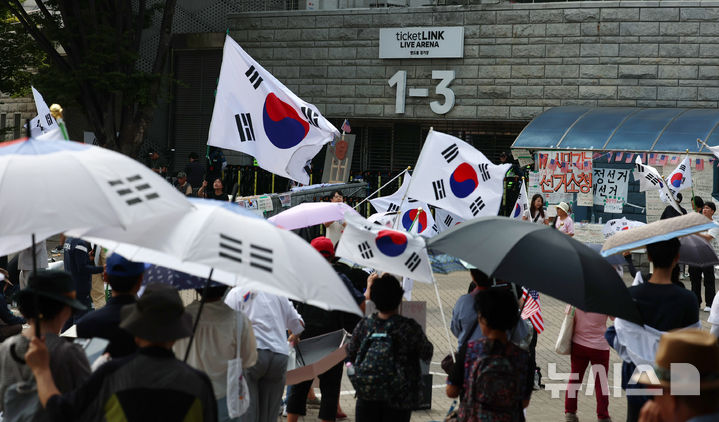 [서울=뉴시스] 조성우 기자 = 18일 오후 6.3 지방선거 투표용지 부족 사태를 규탄하는 시위가 14일째 열리고 있는 서울 송파구 올림픽공원 핸드볼경기장 앞에서 시위 참가자들이 규탄 구호를 외치고 있다. 2026.06.18. xconfind@newsis.com