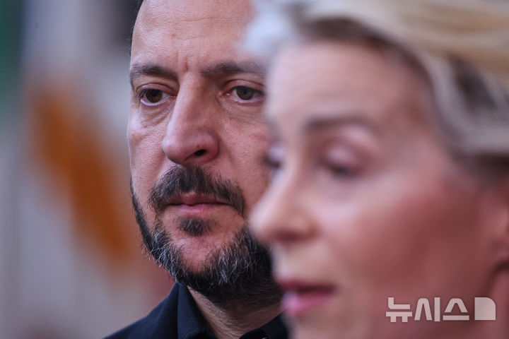 Ukraine's President Volodymyr Zelenskyy, left, listens to European Commission President Ursula von der Leyen talking to journalists as they arrive for the EU summit in Brussels, Thursday, June 18, 2026. (AP Photo/Omar Havana)