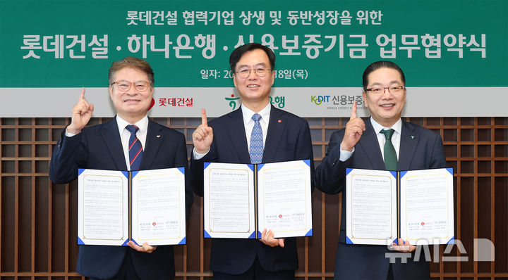 [서울=뉴시스]하나은행은 지난 18일 을지로 본점에서 롯데건설, 신용보증기금과 함께 '롯데건설 협력기업 상생 및 동반성장을 위한 금융지원 업무협약'을 체결했다. 이날 협약식에 참석한 이호성 하나은행장(사진 오른쪽)이 오일근 롯데건설 대표이사(사진 가운데), 강승준 신용보증기금 이사장(사진 왼쪽)과 함께 업무 협약서를 들고 기념촬영을 하고 있다. (사진=하나은행 제공). 2026.06.19, photo@newsis.com 