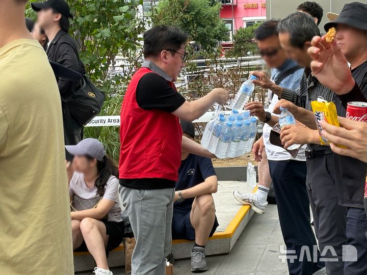 [서울=뉴시스] 권민지 기자 =신세계백화점 관계자가 신세계스퀘어에서 생중계하는 월드컵 대한민국-멕시코전 응원 현장을 찾은 시민들에게 생수를 나눠주고 있다. 2026.06.19. ming@newsis.com