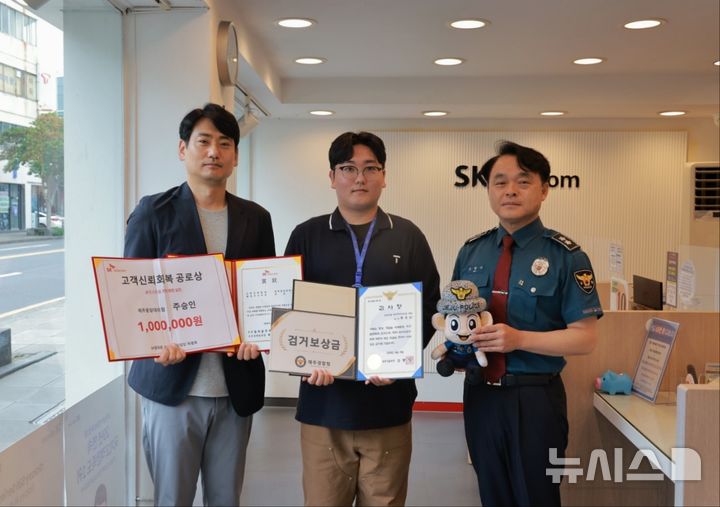 [제주=뉴시스] 고평기(왼쪽) 제주경찰청장이 19일 오전 SKT 제주중앙점을 방문해 6000만원 상당의 보이스피싱 피해를 예방한 주승인(가운데) 점장에게 감사장을 수여하고 기념사진을 찍고 있다. (사진=제주경찰청 제공) 2026.06.19. photo@newsis.com