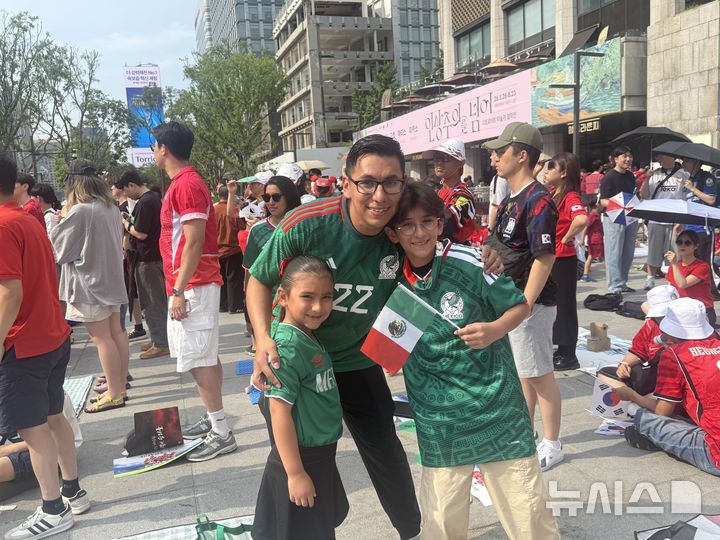 [서울=뉴시스]이송이 인턴기자, 우연지 인턴기자 = 멕시코에서 온 가브리엘(오른쪽) 군이 19일(한국시간) 오전 서울 광화문광장에서 가족과 함께 거리응원을 펼쳤다.