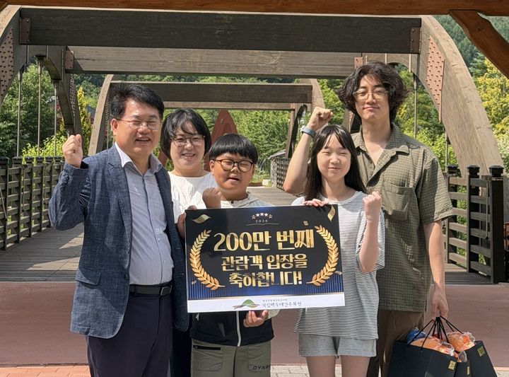 [봉화=뉴시스] 이규명 국립백두대간수목원장(왼쪽에서 첫 번째)이 200만번째 관람객 박재현씨 및 영주 서벽초등학교 학생들과 기념사진을 찍고 있다. (사진=한국수목원정원관리원 제공) 2026.06.19. photo@newsis.com *재판매 및 DB 금지