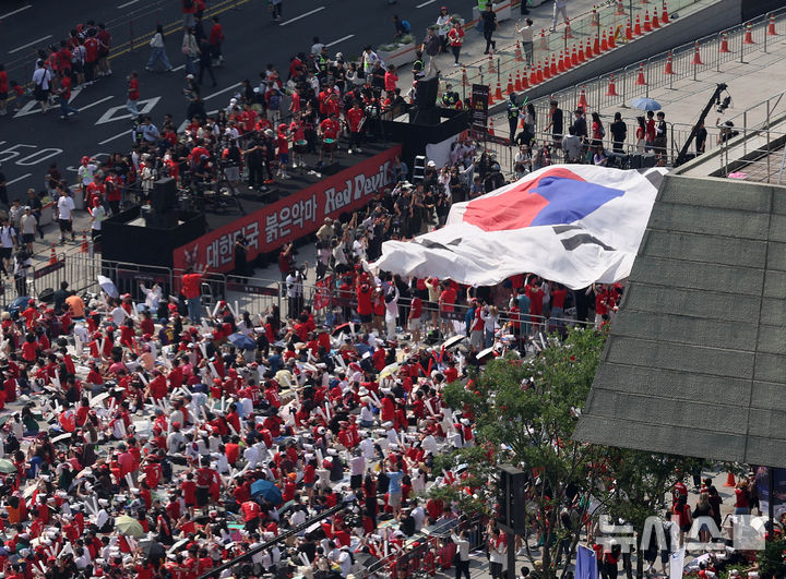 [서울=뉴시스] 조수정 기자 = 19일 오전 서울 종로구 광화문광장에서 시민들이 한국 축구대표팀의 2026 북중미 월드컵 조별리그 2차전 멕시코전을 관전하며 대형 태극기를 들어올리고 있다. 2026.06.19. chocrystal@newsis.com