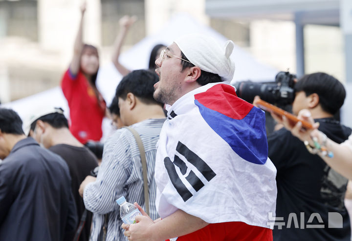 [서울=뉴시스] 김혜진 기자 = 2026 북중미 월드컵 조별리그 A조 2차전 한국과 멕시코 경기가 열리는 19일 서울 중구 신세계백화점 본점 앞에서 외국인 관광객들이 응원을 펼치고 있다. 2026.06.19. jini@newsis.com