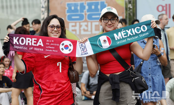 [서울=뉴시스] 김혜진 기자 = 2026 북중미 월드컵 조별리그 A조 2차전 한국과 멕시코 경기가 열리는 19일 서울 중구 신세계백화점 본점 앞에서 외국인 관광객들이 응원을 펼치고 있다. 2026.06.19. jini@newsis.com