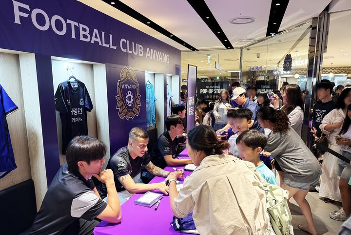 [서울=뉴시스] 롯데백화점 평촌점 지하 1층에서 열린 'FC 안양' 팝업을 방문한 고객들이 구단 선수들의 기념 사인을 받는 모습(사진=롯데백화점 제공) *재판매 및 DB 금지