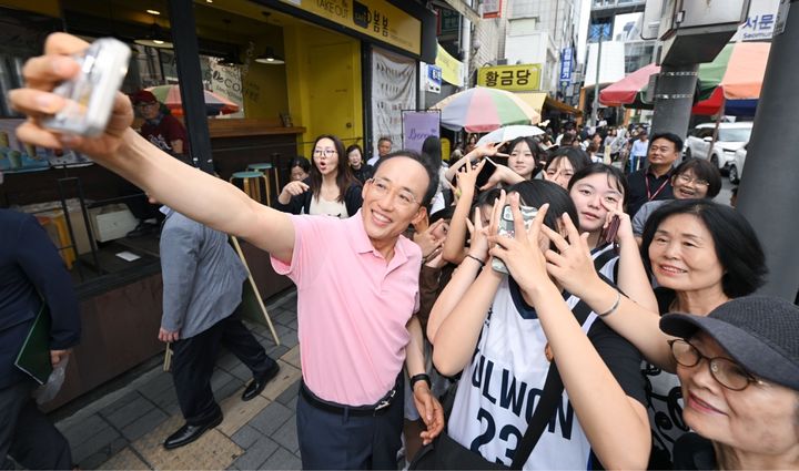 [대구=뉴시스]추경호 대구시장 당선인이 20일 오후 서문시장을 방문해 시민들의 셀카 촬영 요청에 응하고 있다(사진=대구시장직 인수위원회 제공) 2026.06.21 photo@newsis.com *재판매 및 DB 금지