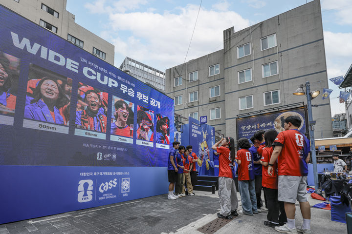 [서울=뉴시스] 대한민국 축구국가대표팀 경기 당일 카스 뷰잉펍 현장에서 카스 와이드 컵 이벤트에 참여하고 있는 축구 팬들(사진=오비맥주 제공) *재판매 및 DB 금지